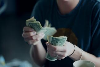 focus photography of person counting dollar banknotes by Alexander Grey courtesy of Unsplash.