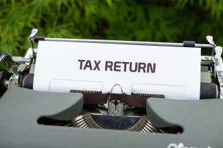 a close up of a typewriter with a tax return sign on it by Markus Winkler courtesy of Unsplash.
