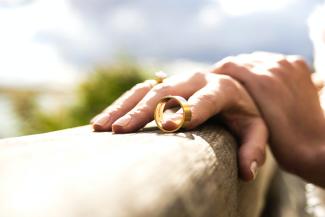 person holding gold wedding band by engin akyurt courtesy of Unsplash.