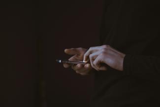 silhouette photo of person holding smartphone by Gilles Lambert courtesy of Unsplash.