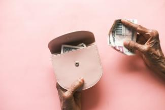 brown leather hand bag on pink table by Towfiqu barbhuiya courtesy of Unsplash.