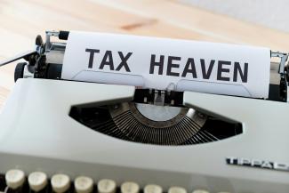 a close up of a typewriter with a tax heaven sign on it by Markus Winkler courtesy of Unsplash.