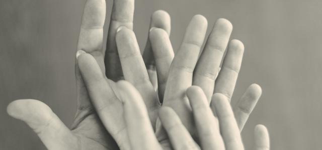 grayscale photo of family's hands by Ricardo Moura courtesy of Unsplash.